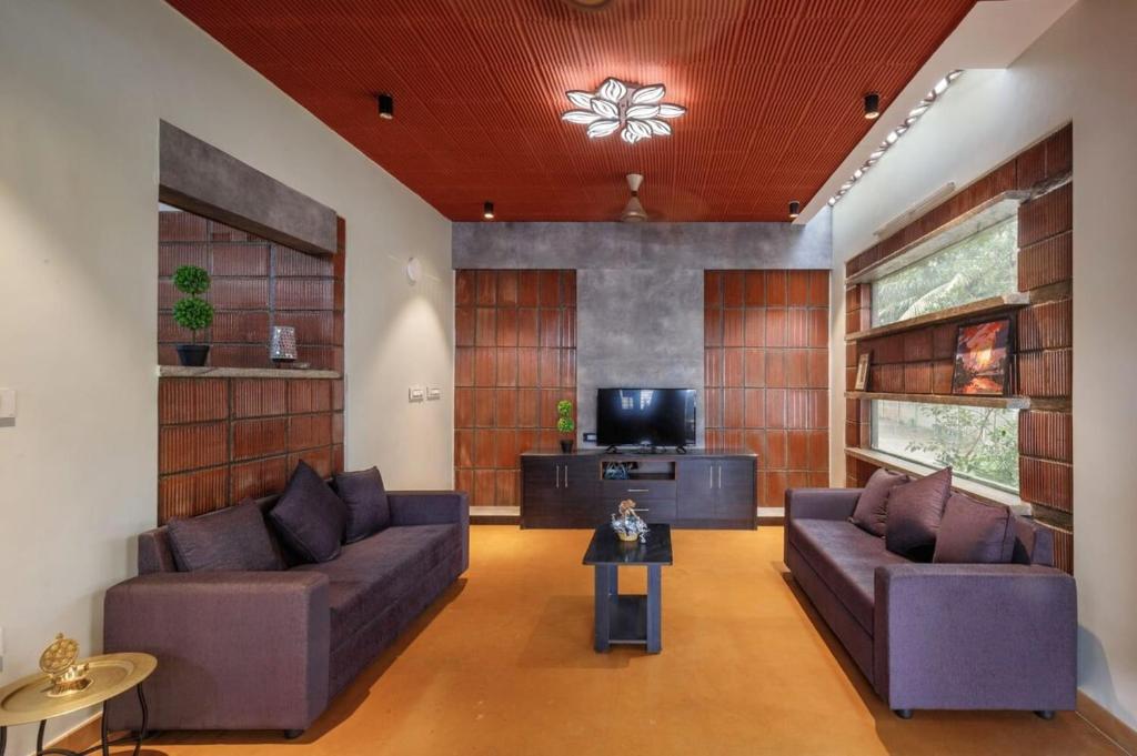 uma sala de estar com dois sofás e uma televisão em Zenith Edge Villa by JadeCaps 3BHK Duplex Wifi em Bangalore