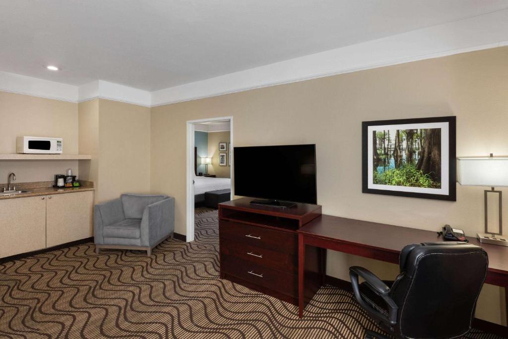 a hotel room with a desk and a television at La Quinta by Wyndham Houma in Houma
