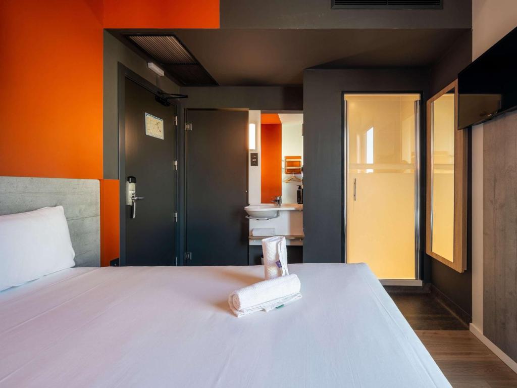 a bedroom with a bed with a book on it at Ibis Budget Madrid Centro Lavapies in Madrid