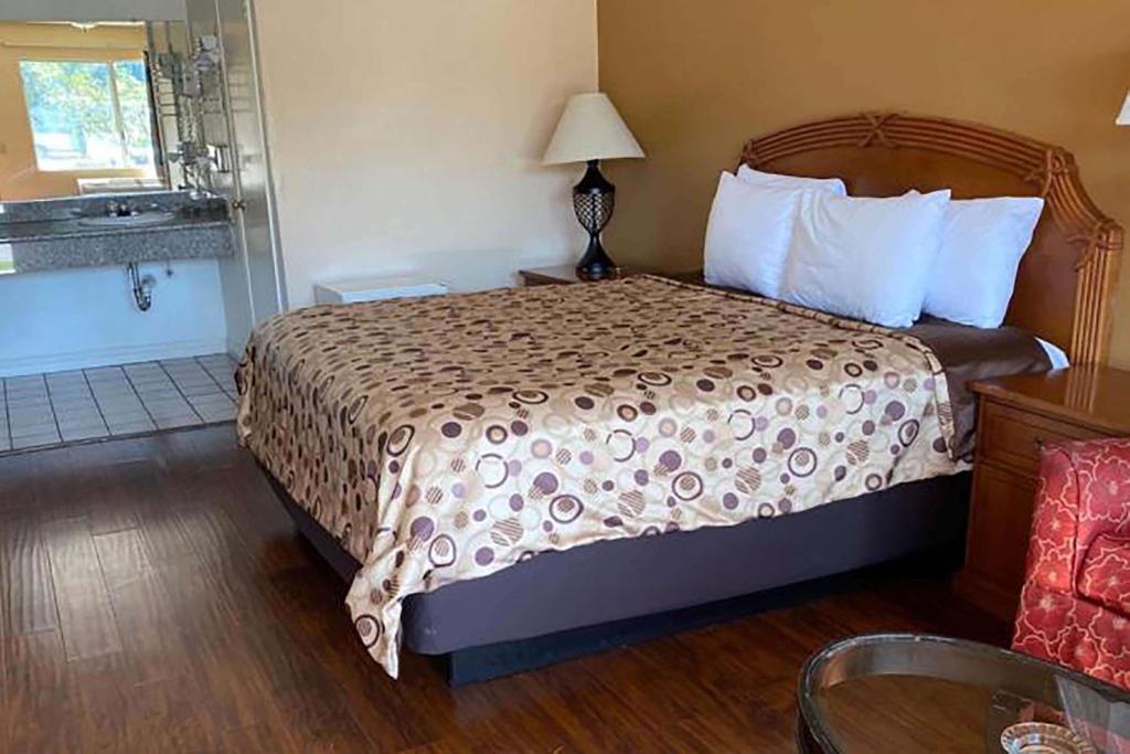 een hotelkamer met een bed en een badkamer bij Howard Johnson by Wyndham Azusa in Azusa