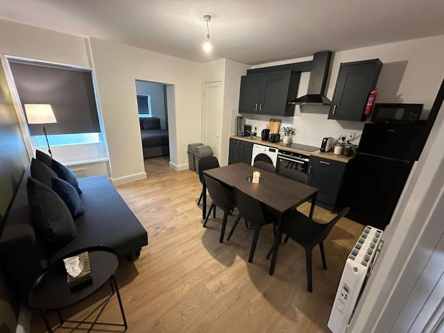 a kitchen and living room with a table and a couch at Convenient & Central Apartment in Dublin