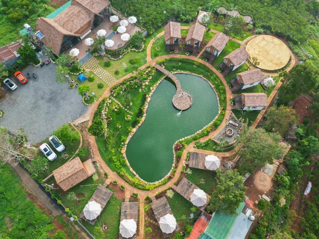 einen Blick über einen Park mit einem Teich in der Unterkunft The Homilá Bảo Lộc - Hill View Bungalow & Glamping in Bảo Lộc