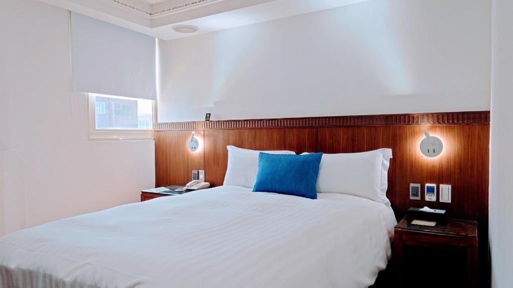 a bedroom with a large bed with a blue pillow at Hub Hotel Kaohsiung Cisian Branch in Kaohsiung