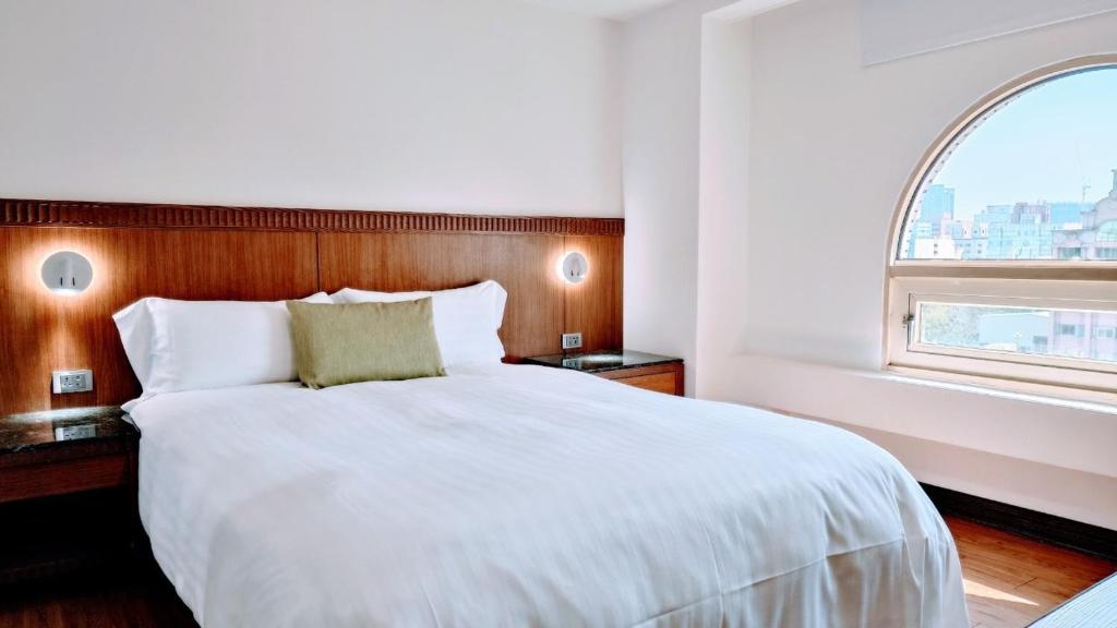 a bedroom with a large white bed with a window at Hub Hotel Kaohsiung Cisian Branch in Kaohsiung