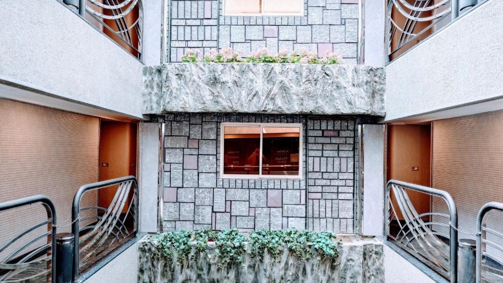 a building with a window with plants on it at Hub Hotel Kaohsiung Cisian Branch in Kaohsiung