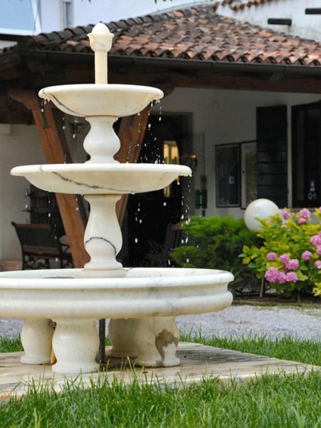 a white fountain in front of a house at Hotel Valdor in Cavallino-Treporti
