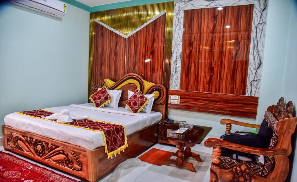 a bedroom with a king sized bed and a chair at Hotel Anita in Baripāda
