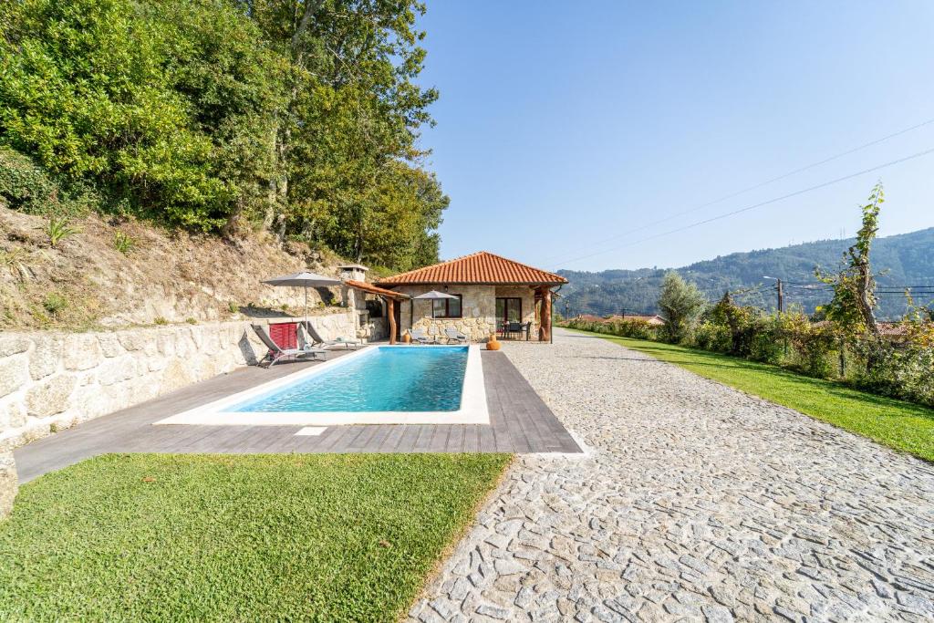 ein Haus mit einem Swimmingpool neben einem Gebäude in der Unterkunft Assento do Cávado by House and People in Valdosende