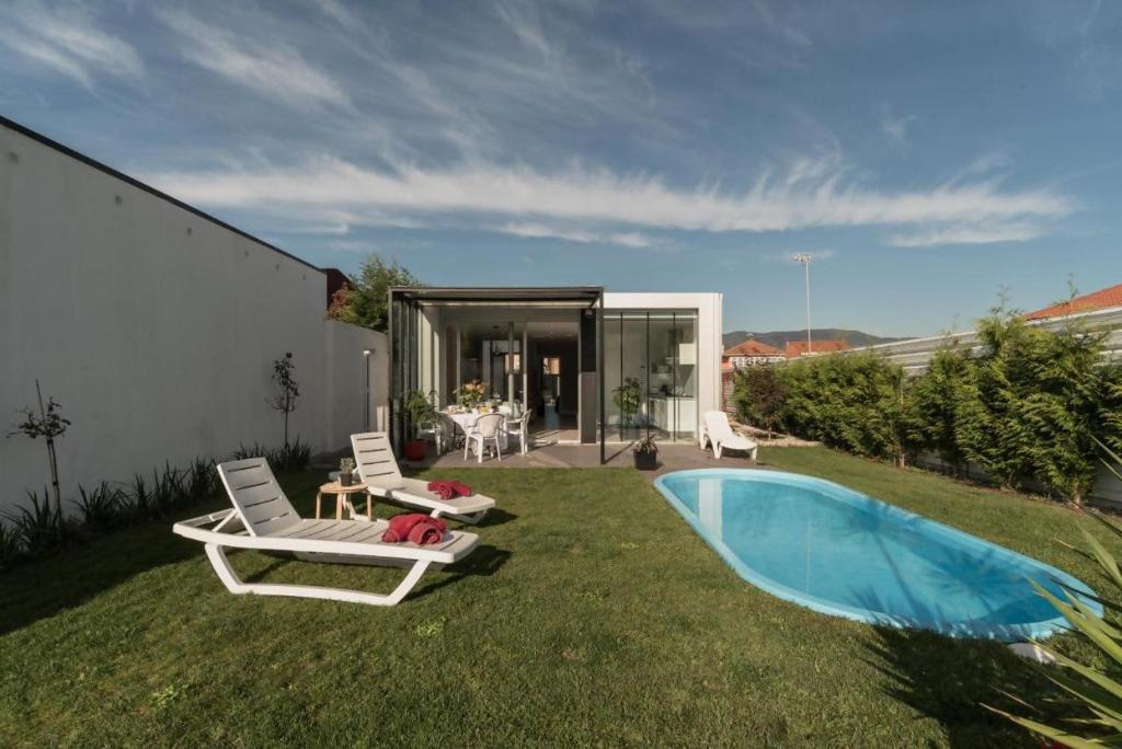 a yard with two chairs and a swimming pool at Casa Calima in Esteiro