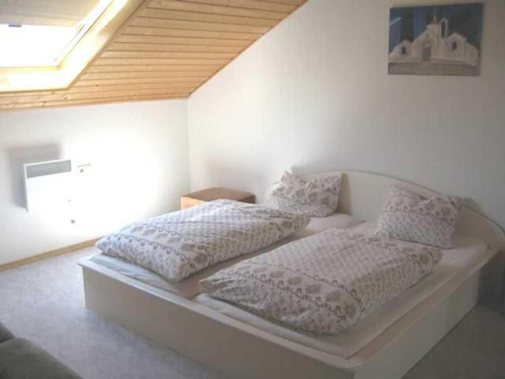 ein Bett mit zwei Kissen auf einem Zimmer in der Unterkunft Haus Sprißler in Markdorf