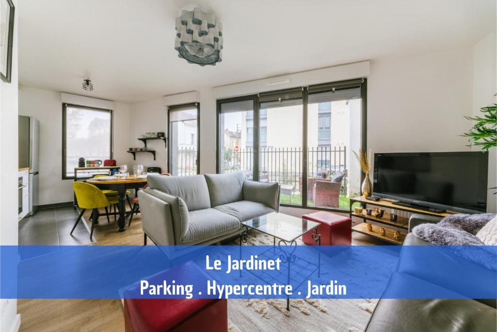 a living room with a couch and a tv at Le Jardinet - parking gratuit dans la résidence - Jardin ensoleillé in Fontainebleau