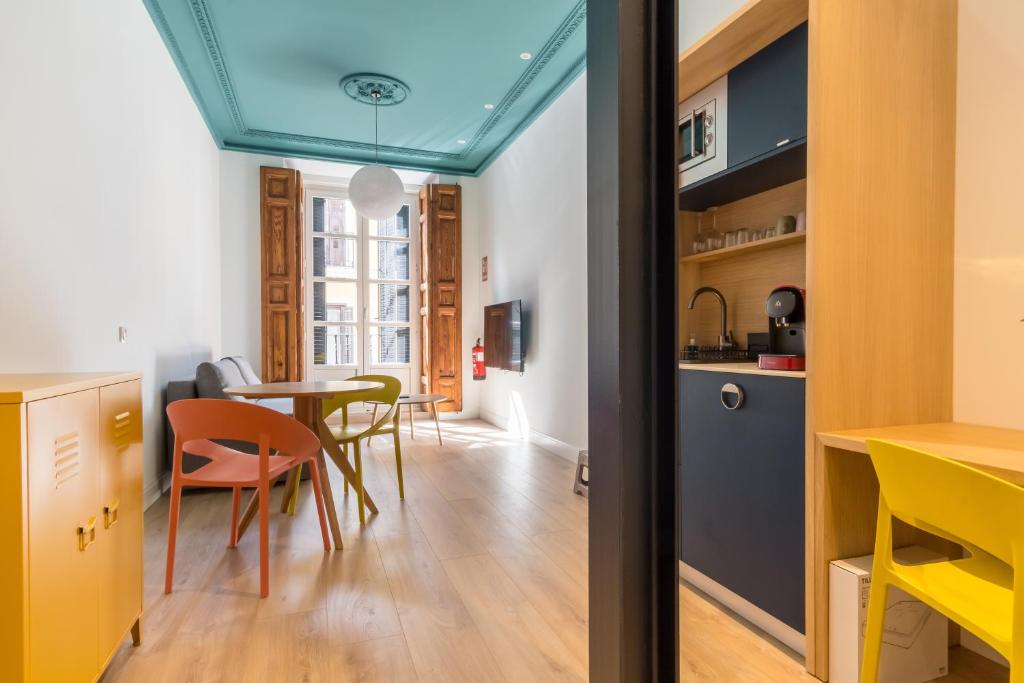 Una cocina y un comedor con mesa y sillas. en Siete Monos, en Madrid