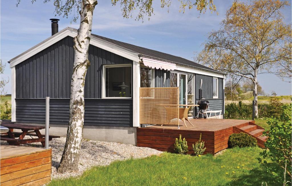 een klein huis met een terras en een tafel bij Beautiful Home In Otterup With 2 Bedrooms And Wifi in Otterup