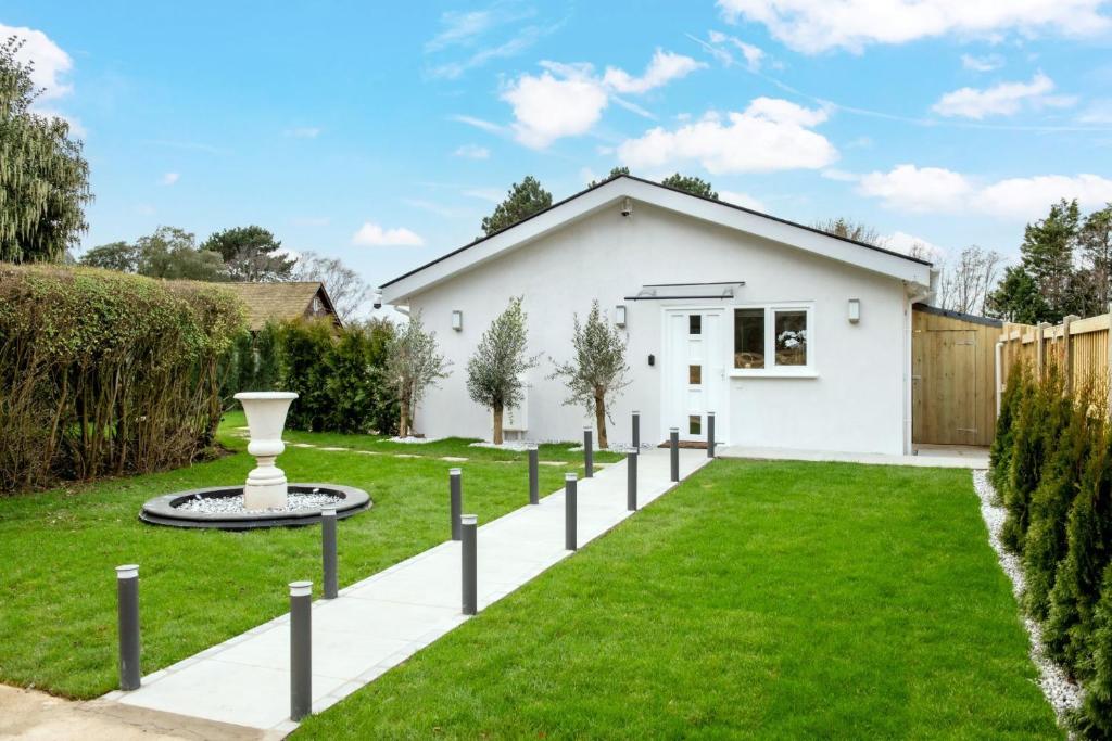 ein weißes Haus mit einem grünen Hof in der Unterkunft Paisley Cottage in Sandwich