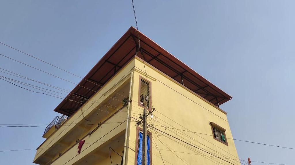 a tall yellow building with a brown roof at sawpanpurty in Pune