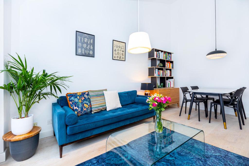 a living room with a blue couch and a table at Stylish 1BR apt, 7min Archway Tube & Holloway Rd in London