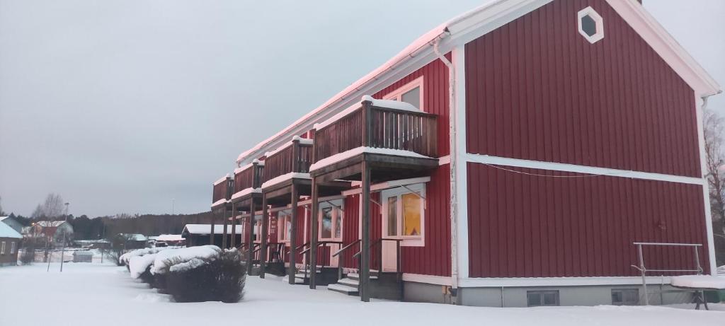 a red barn with snow on the ground at SunnemosLantLiv in Sunnemo