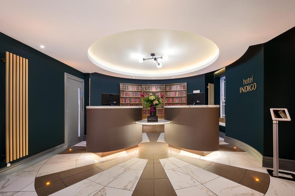 a lobby with a table with a vase of flowers at Hotel Indigo - Edinburgh - Princes Street by IHG in Edinburgh