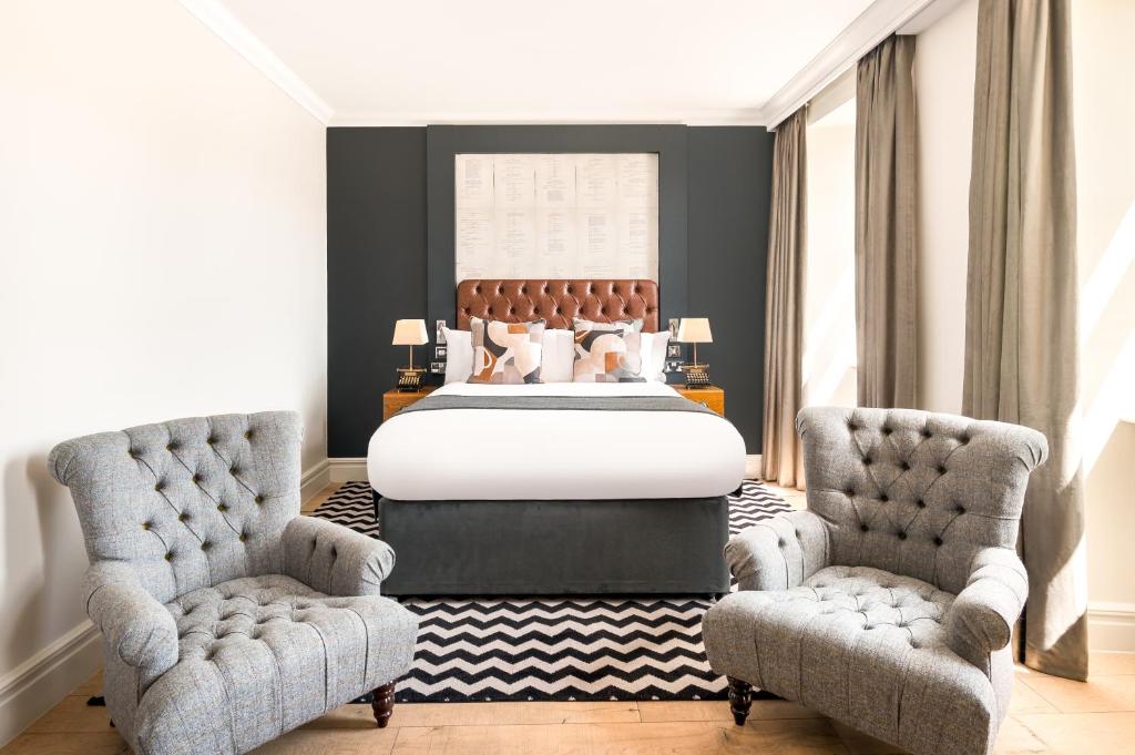a bedroom with a bed and two chairs at Hotel Indigo - Edinburgh - Princes Street by IHG in Edinburgh