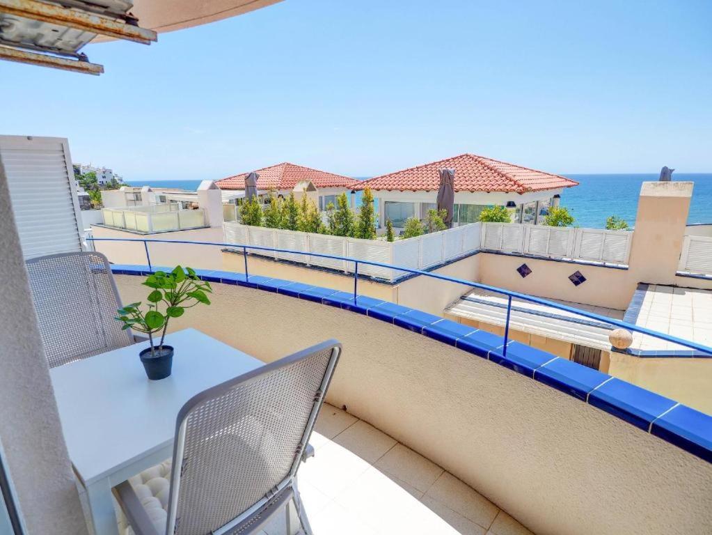 balkon ze stołem i krzesłami oraz oceanem w obiekcie Apartment by the Sea by Hello Homes Sitges w mieście Sitges