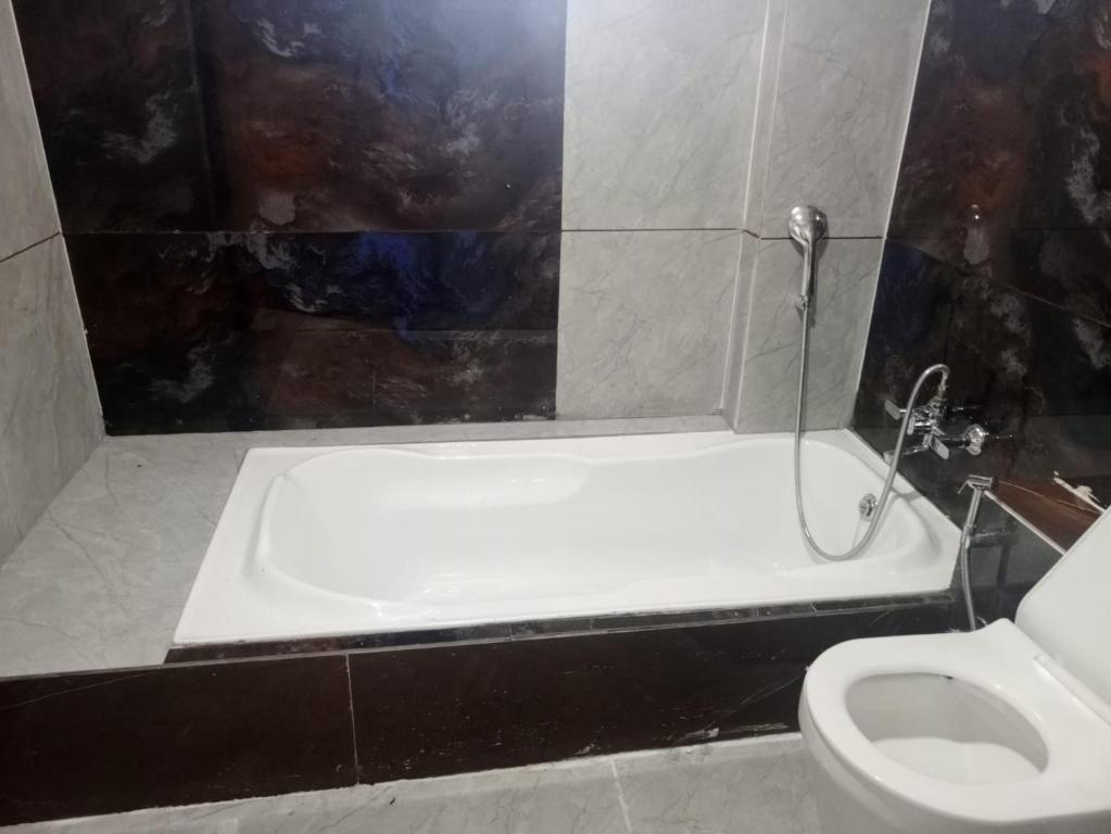 a bathroom with a bath tub and a toilet at Hotel Red Blue,Ahmedabad in Naroda