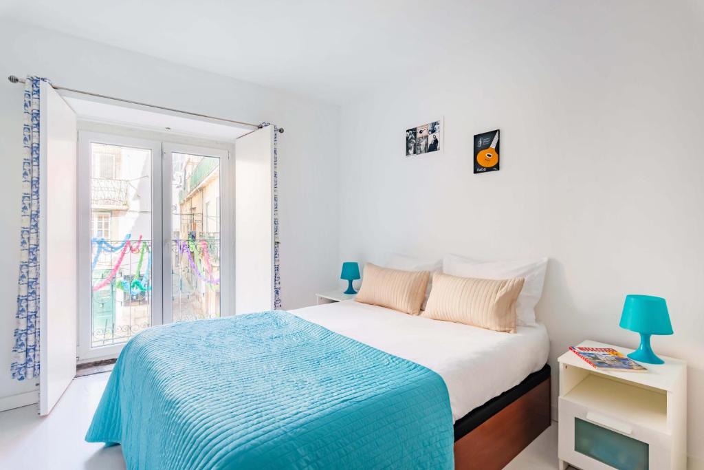 ein weißes Schlafzimmer mit einem Bett und einem Fenster in der Unterkunft Alfama Studios in Lissabon