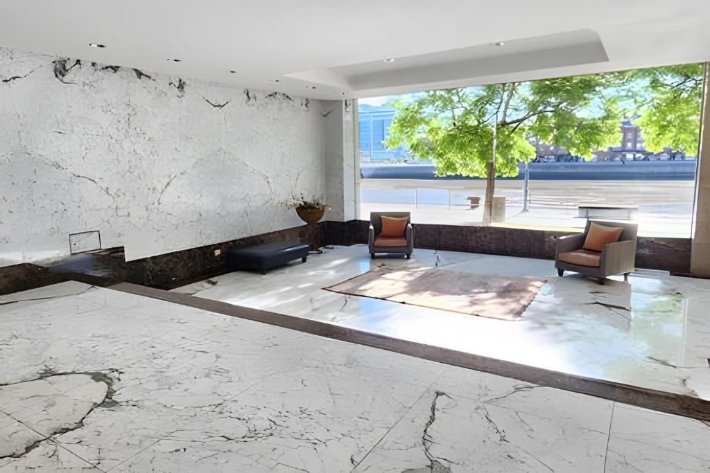 a lobby with two chairs and a marble floor at STUDIO MODERNO EN PUERTO MADERO FRENTE AL HOTEL MADERO in Buenos Aires