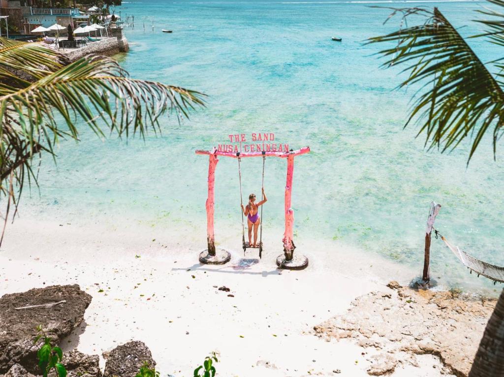 a statue of a woman on a swing on the beach at Best Choice Nusa Lembongan in Nusa Lembongan