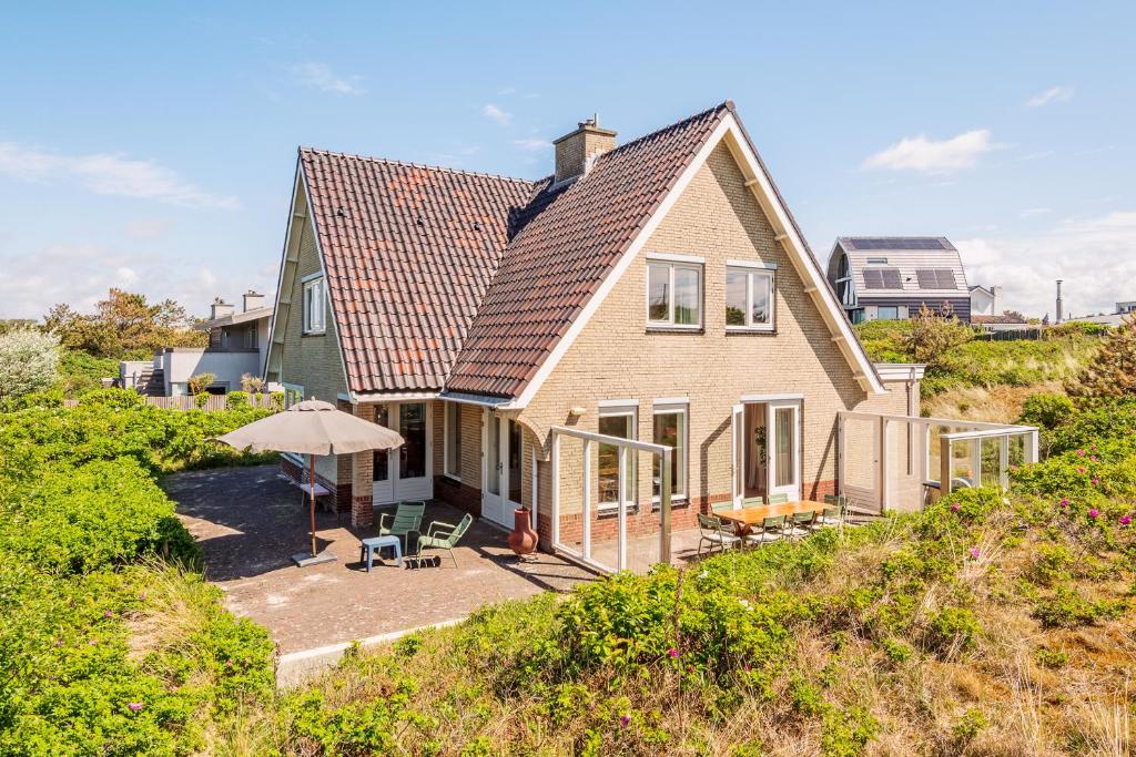 une maison avec toit au sommet d'une colline dans l'établissement Villa Duin en Strand, à Bergen aan Zee