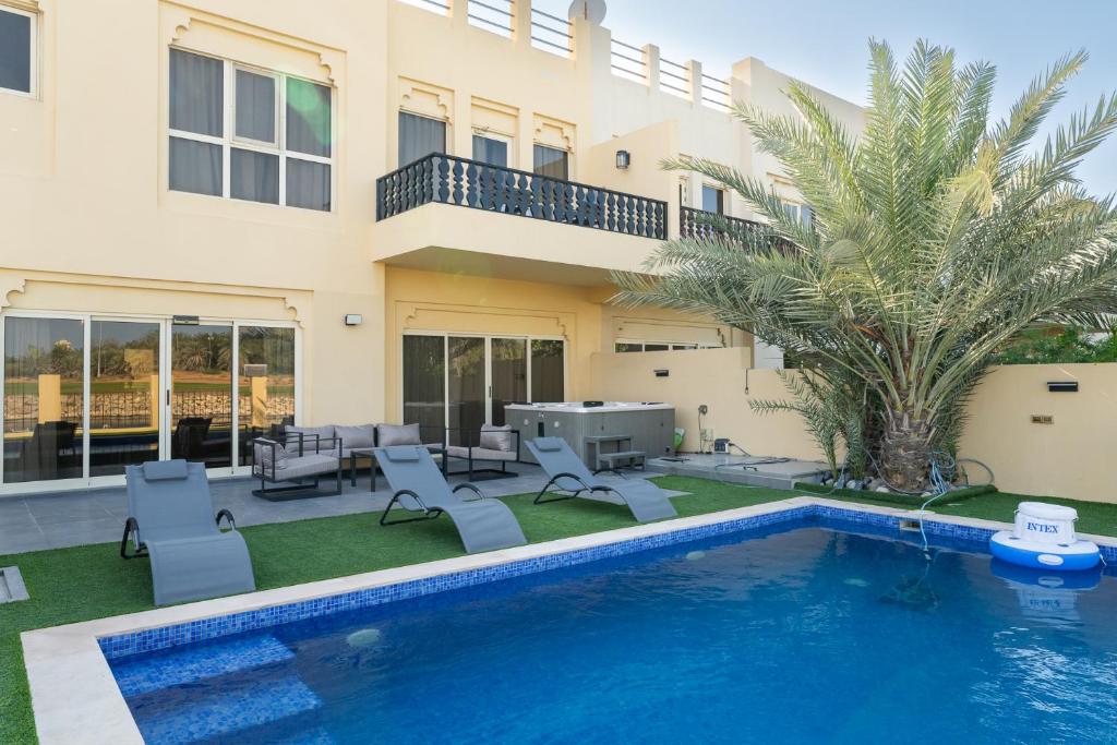 a swimming pool in front of a house at Nasma Luxury Stays - Exquisite 4BR Villa, with a Private Pool in Ras al Khaimah