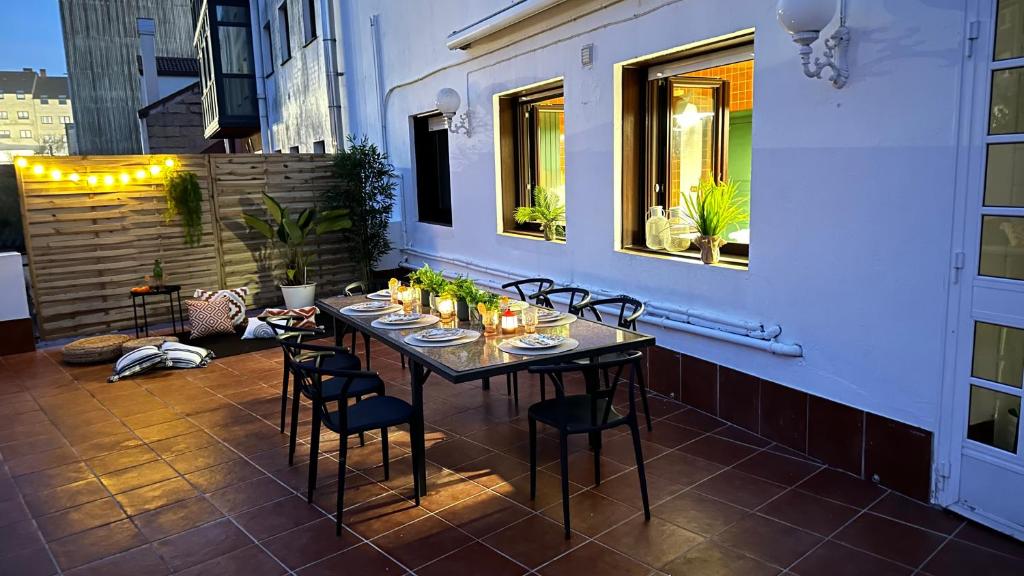 a table on the balcony of a building with chairs at Maison Terrasse Doña Irma in Cambados