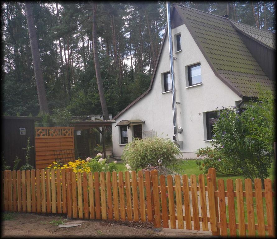 een wit huis met een hek ervoor bij Ferienhaus Borgwall in Krakow am See