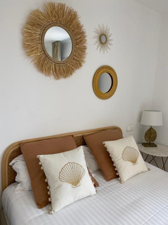 Dormitorio con cama con espejo y almohadas en Villa 418, en Saint-Raphaël