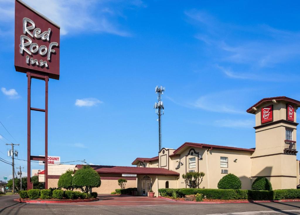 una señal roja de la posada frente a un edificio en Red Roof Inn Dallas - Richardson, en Dallas