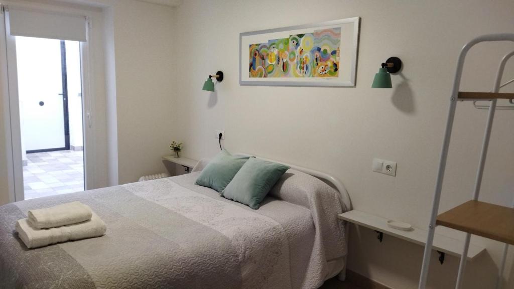 1 dormitorio con 1 cama y una pintura en la pared en Alojamiento "Destino Cazorla", en Cazorla