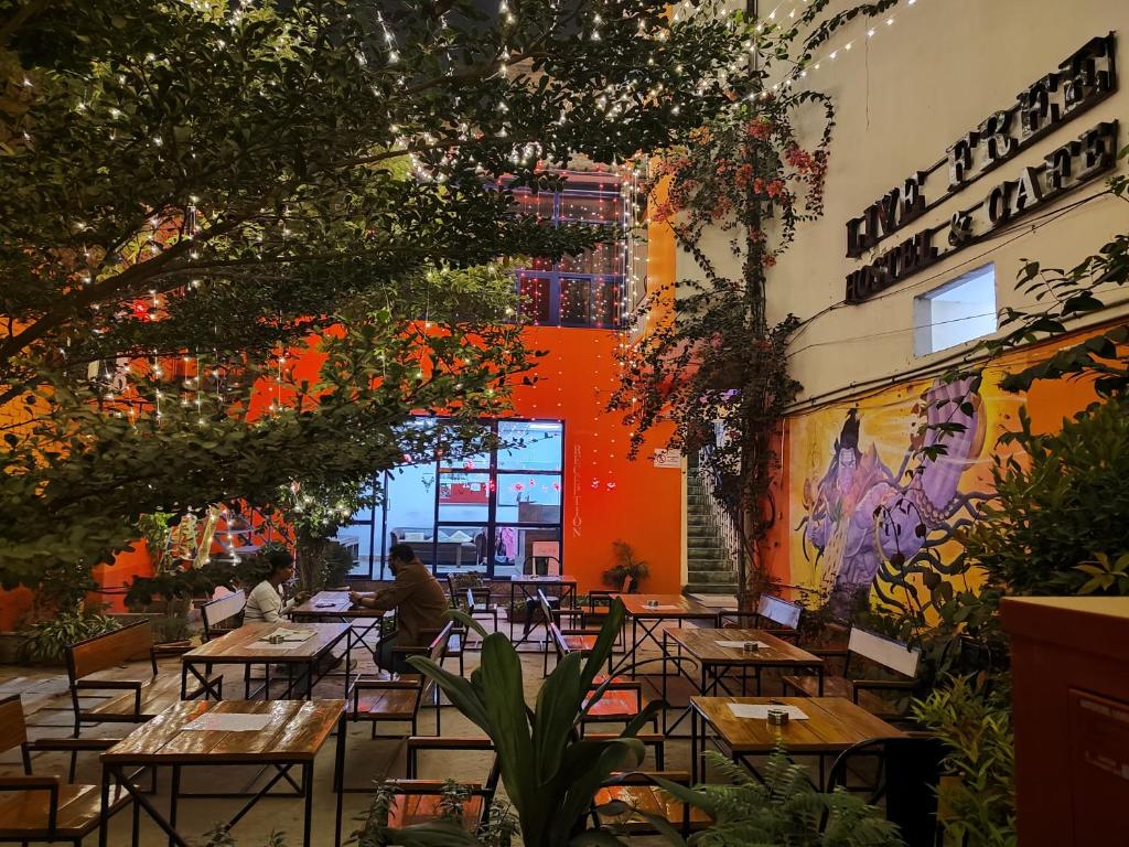 a restaurant with tables and chairs in a building at Live Free Hostel Varanasi in Varanasi