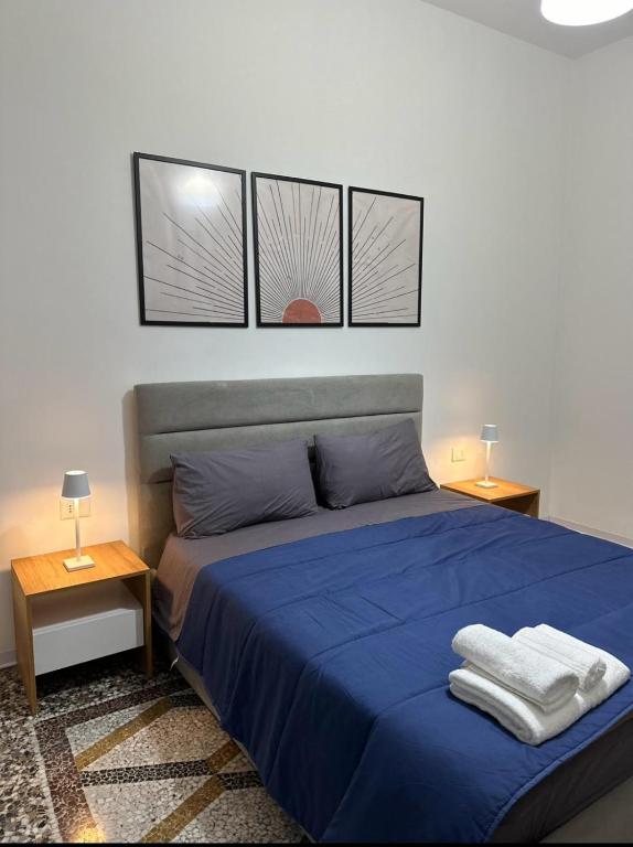 ein Schlafzimmer mit einem blauen Bett mit drei Bildern an der Wand in der Unterkunft Mosaic Inn in Genua