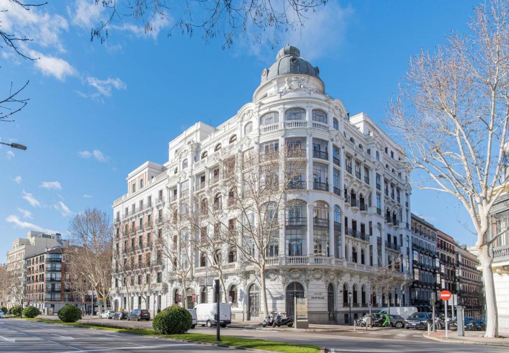 duży biały budynek przy ulicy miejskiej w obiekcie Petit Palace Savoy Alfonso XII w Madrycie