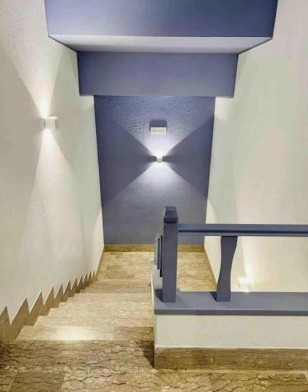 a staircase in a building with a blue ceiling at Les Amis appartamento anzio in Anzio