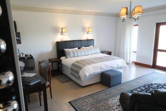 a bedroom with a bed and a living room at Neo Horizon Guest House in Krugersdorp