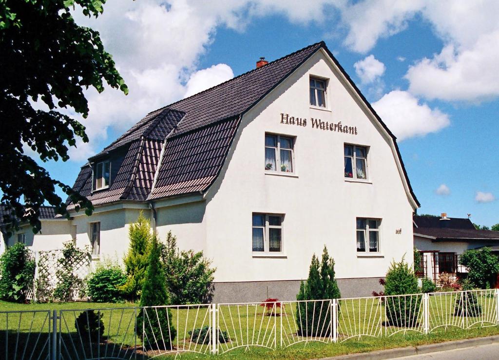 a white house with a sign that reads harvard witchcraft at Haus Waterkant in Breege