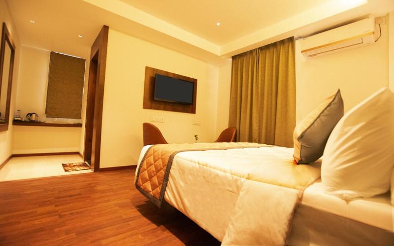 a hotel room with a bed and a television at NAR Comforts in Bangalore