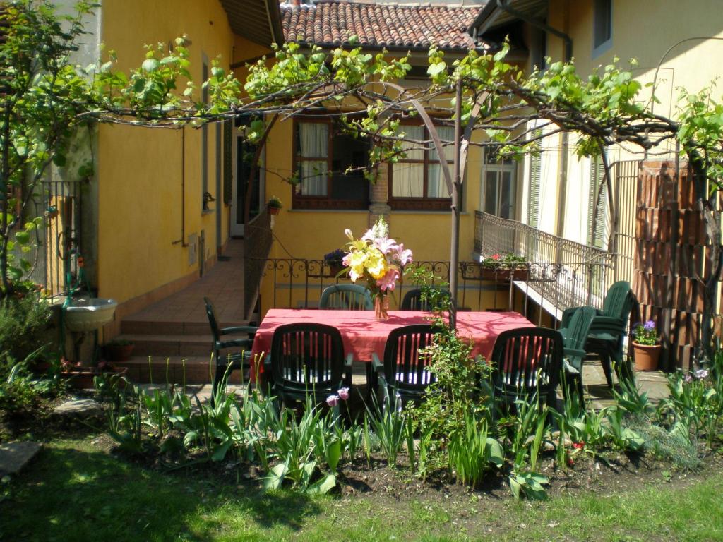 a table with chairs and a vase of flowers on it at Casa Mario Lupo - Apartments and Rooms in Bergamo