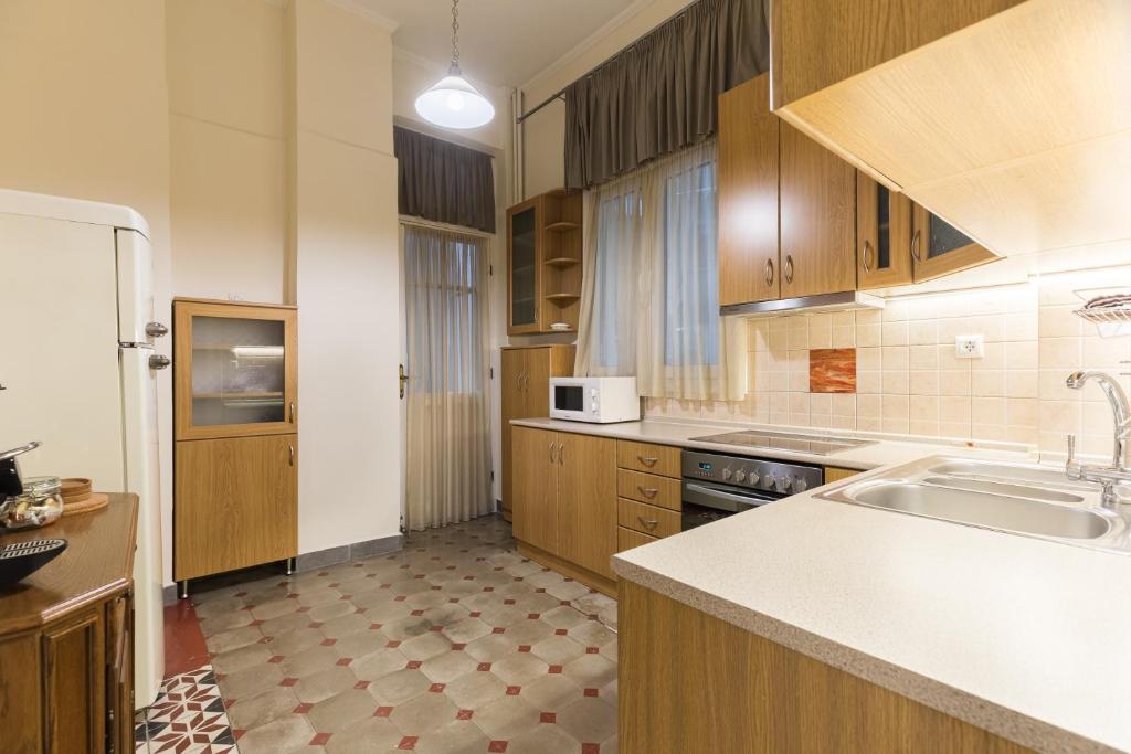 uma grande cozinha com armários de madeira e um lavatório em #Magnolia Apt by halu! Apartments em Tessalônica