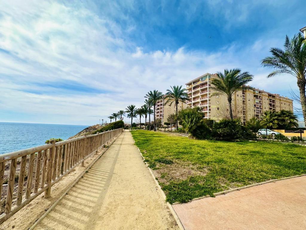 a walkway near the ocean with palm trees and buildings at A1040 - Terramar 1 - 2004 Finestrat in Villajoyosa