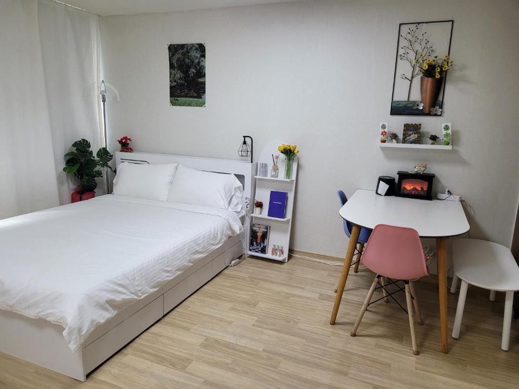 - une petite chambre avec un lit et une table dans l'établissement If House Hongdae, à Séoul