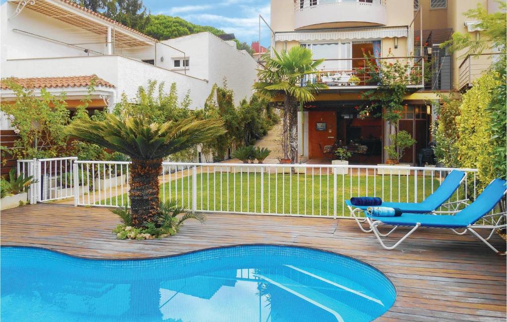 ein Haus mit einem Pool, einem Stuhl und einer Palme in der Unterkunft Amazing Home In Tossa De Mar With Outdoor Swimming Pool in Tossa de Mar