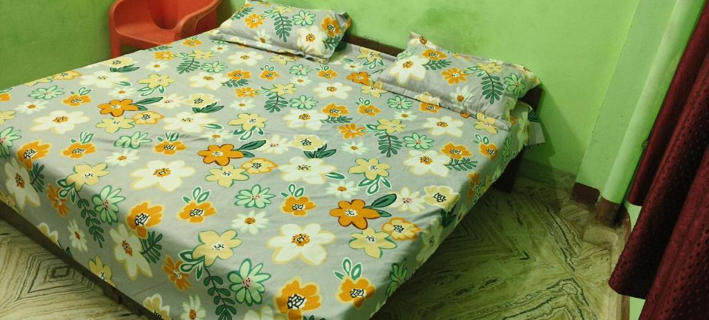 GhāzīpurにあるMaa durga guest houseの花柄の掛け布団と枕が付いたベッド