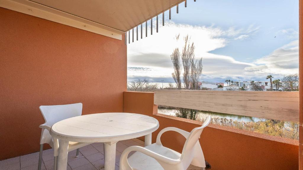 une salle à manger avec une table et des chaises et une fenêtre dans l'établissement PRIMAVERA 218 - Appt lumineux 4 pers, au Cap d'Agde