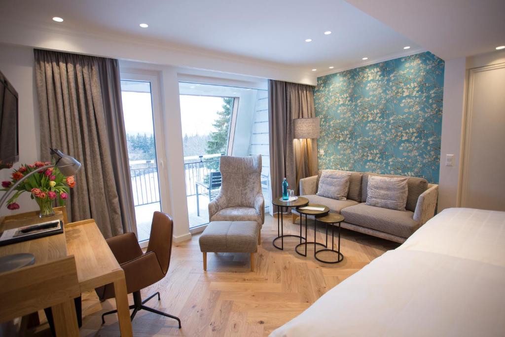een hotelkamer met een bed en een woonkamer bij Hotel Jagdhaus Wiese in Schmallenberg
